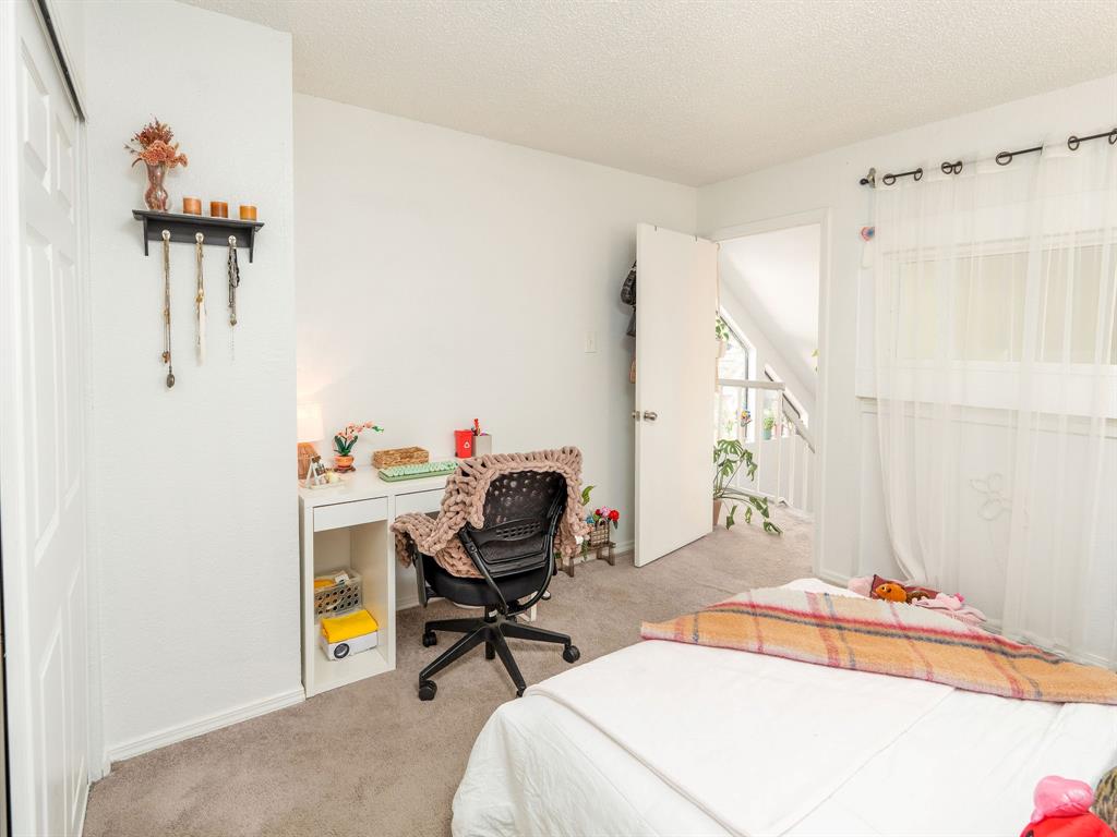 18240 Midway Road, Unit 205 Dallas, TX 75287 - Photo 19 of 27 a bedroom with a bed and a table in it