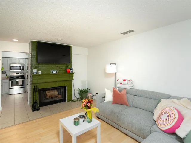 a living room with furniture a flat screen tv and a fireplace
