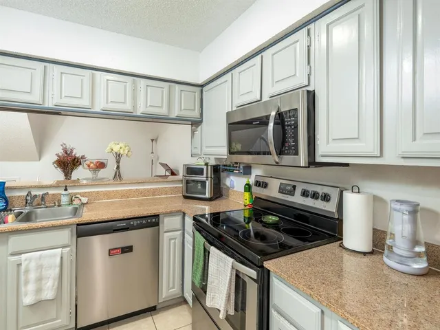 a kitchen with stainless steel appliances a sink dishwasher stove and cabinets