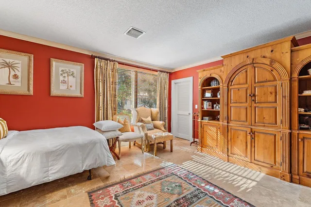 a bedroom with a bed couch and wooden floor