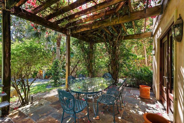 a front view of a house with a yard and tree s