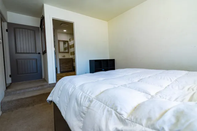 a bedroom with a bed and wooden floor