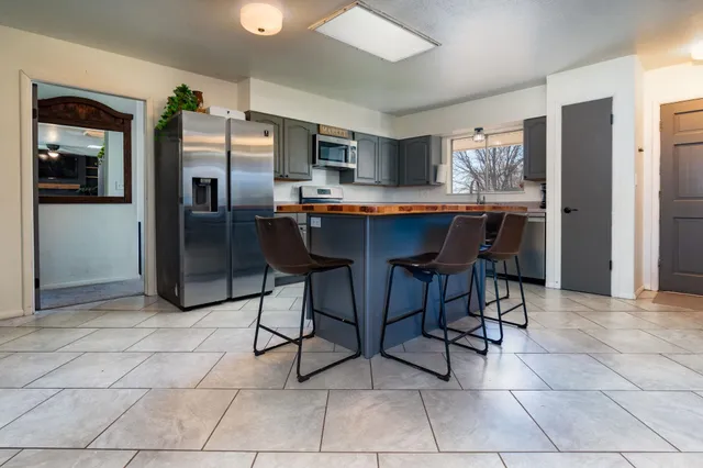 a kitchen with stainless steel appliances granite countertop a refrigerator and a stove top oven