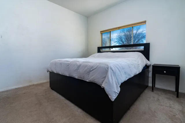 a bed sitting in a bedroom next to a wall paintings