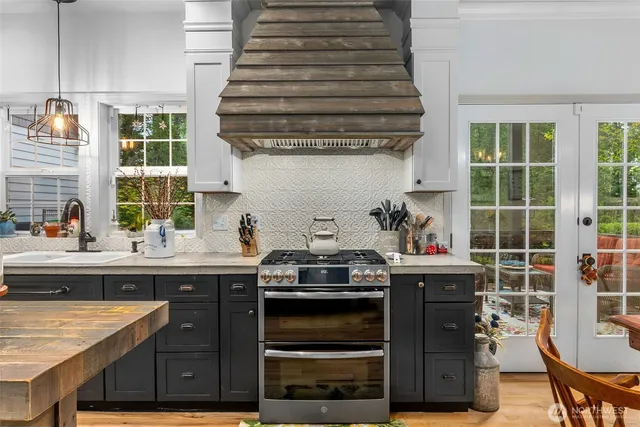 a kitchen with stainless steel appliances granite countertop a stove and a sink