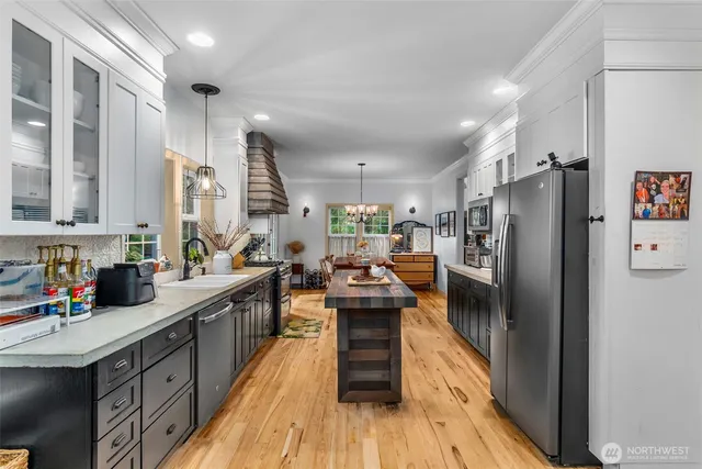a kitchen with refrigerator a stove and a wooden floors