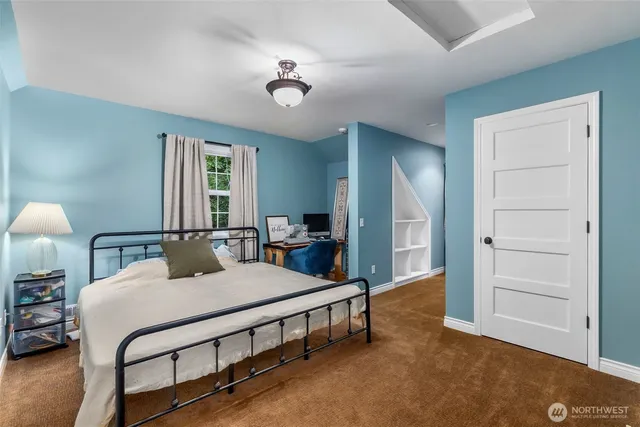 a bedroom with a bed a lamp and a dresser