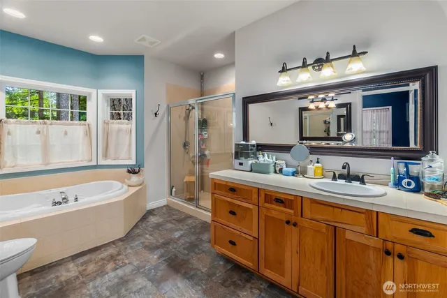 a bathroom with a tub a double vanity sink and mirror