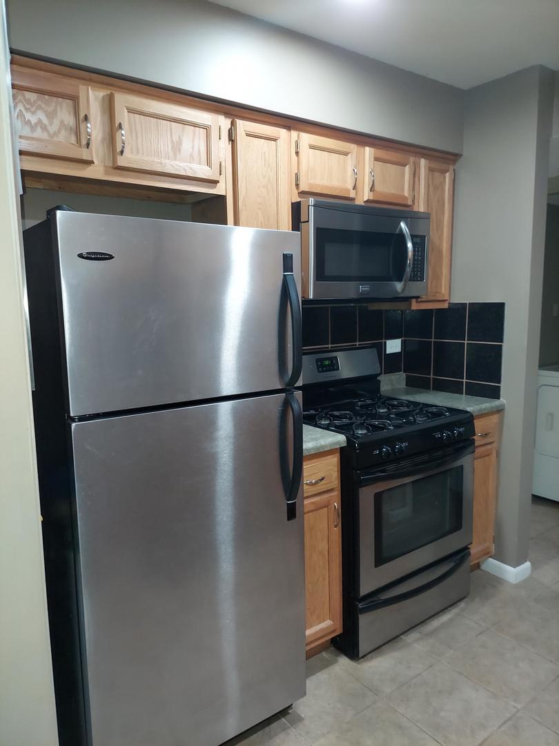 34W951 Stanton Drive, Unit G St. Charles, IL 60174 - Photo 6 of 11 a kitchen with stainless steel appliances granite countertop a refrigerator stove and microwave