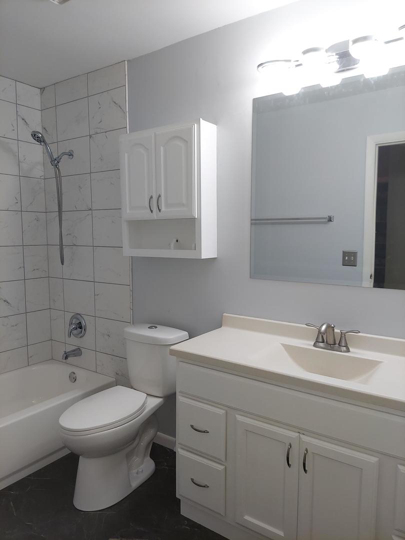 34W951 Stanton Drive, Unit G St. Charles, IL 60174 - Photo 9 of 11 a bathroom with a sink a toilet and shower