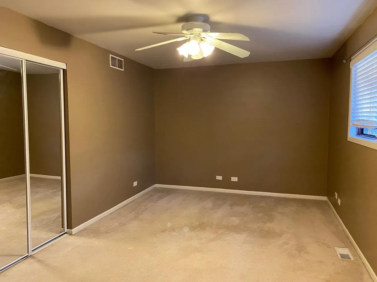 34W951 Stanton Drive, Unit G St. Charles, IL 60174 - Photo 10 of 11 en empty room with closet and chandelier fan
