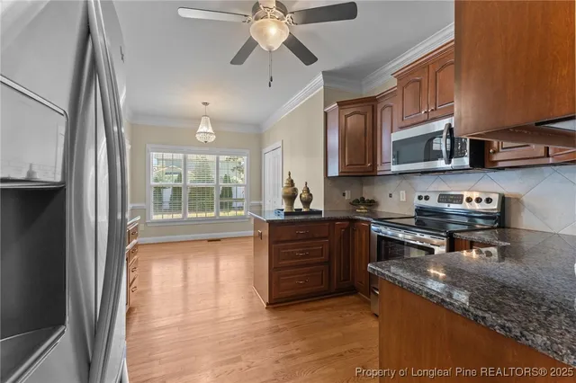 a kitchen with stainless steel appliances granite countertop a stove a sink and a refrigerator