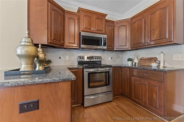 a kitchen with stainless steel appliances granite countertop a stove a sink dishwasher and a microwave