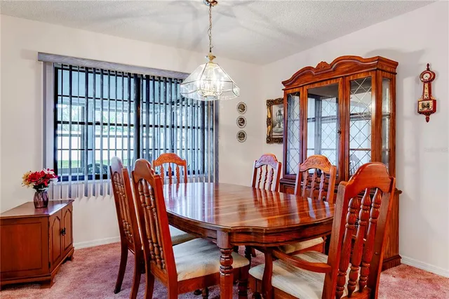 a dining room with furniture a chandelier and wooden floor