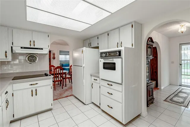 a kitchen with white cabinets and white appliances