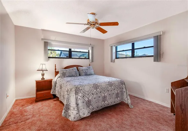 a bedroom with a bed and a ceiling fan