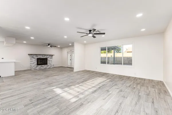 a view of an empty room with a fireplace and a window