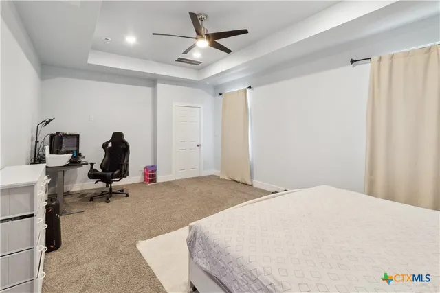 a bedroom with a bed and a ceiling fan