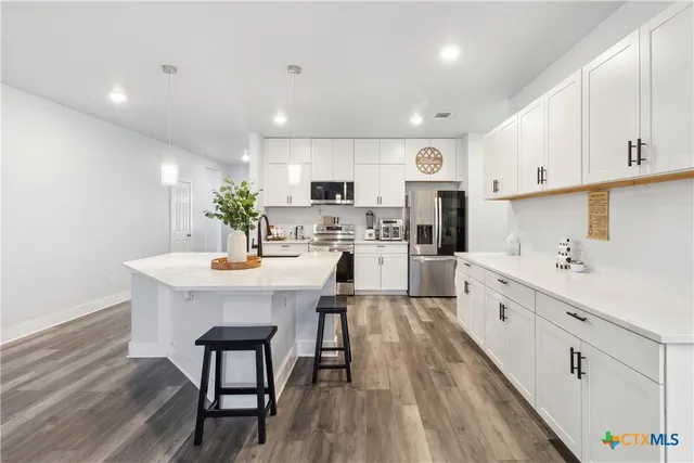 a kitchen with white cabinets and stainless steel appliances