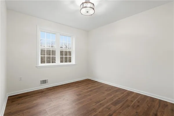 a view of a room with wooden floor and windows