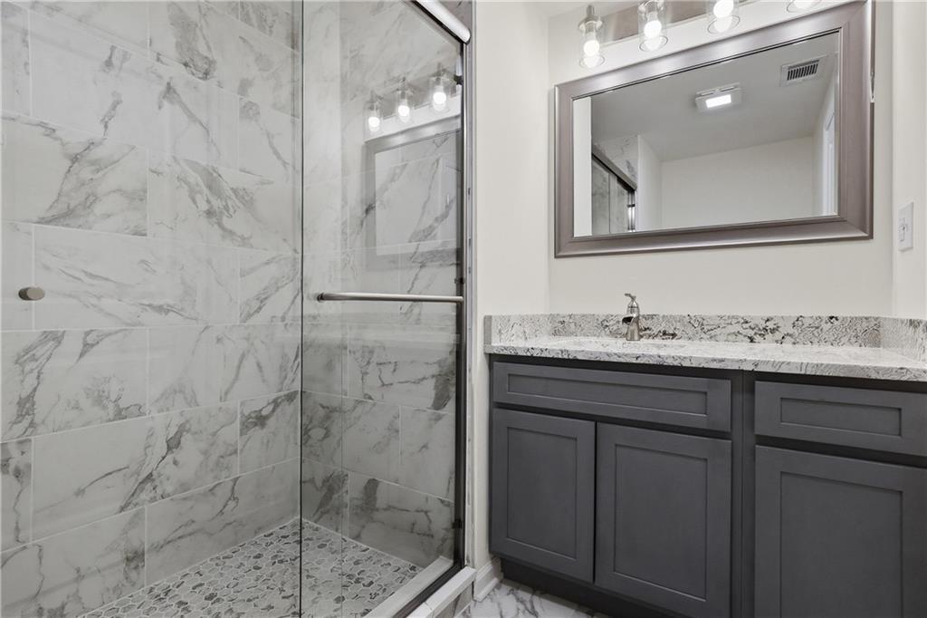 5149 Watters Road Lower Burrell, PA 15068 - Photo 37 of 49 a bathroom with a granite countertop sink a mirror and shower