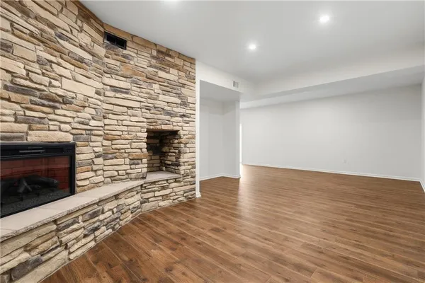 an empty room with wooden floor and fireplace