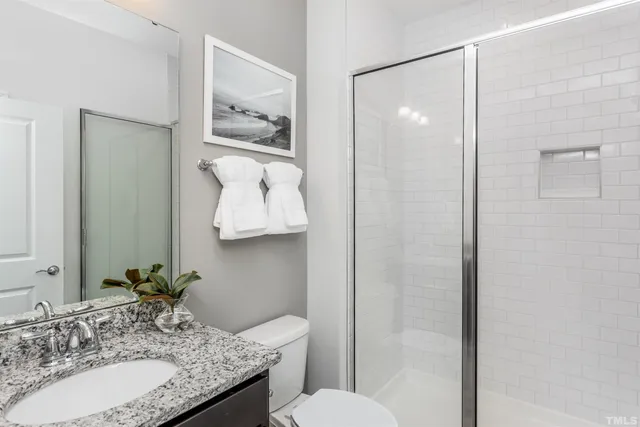 a bathroom with a granite countertop sink toilet and shower