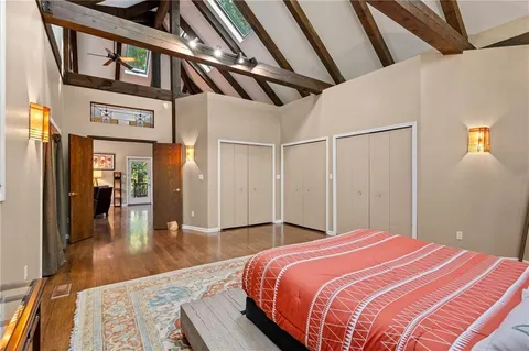 a bedroom with a large bed and wooden floor