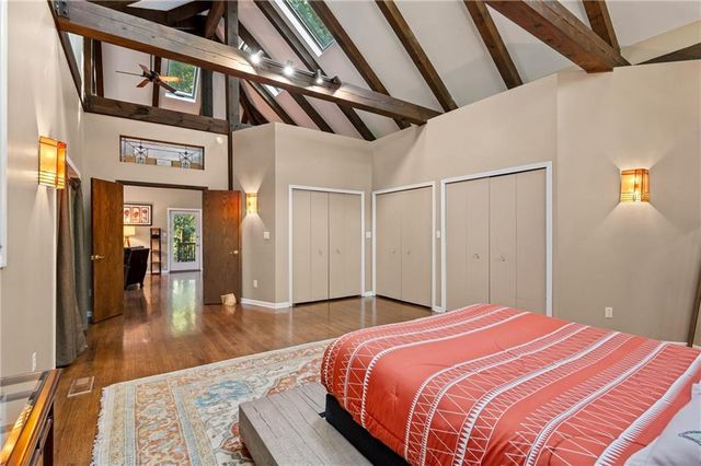 a bedroom with a large bed and wooden floor