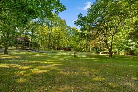 an aerial view of residential houses with outdoor space and trees