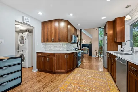 a large kitchen with stainless steel appliances granite countertop a stove a sink and a refrigerator