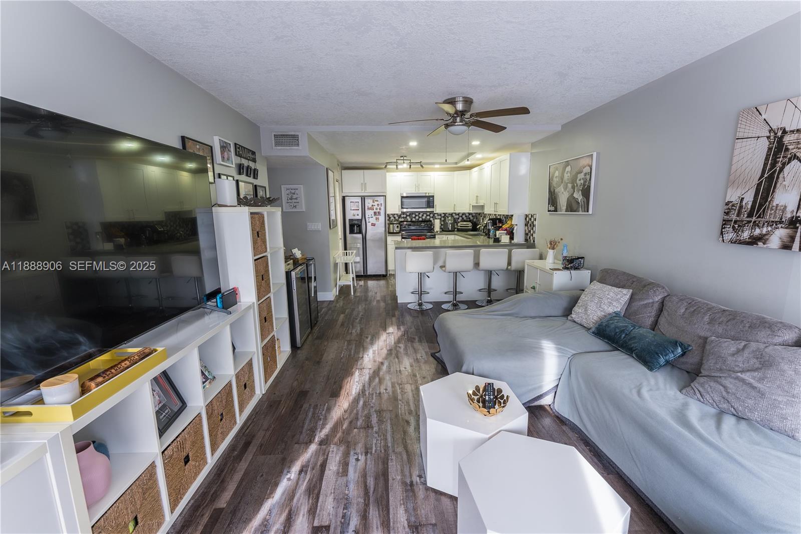 8810 Southwest 132nd Place, Unit 404DN Miami, FL 33186 - Photo 11 of 20 a living room with furniture and a flat screen tv