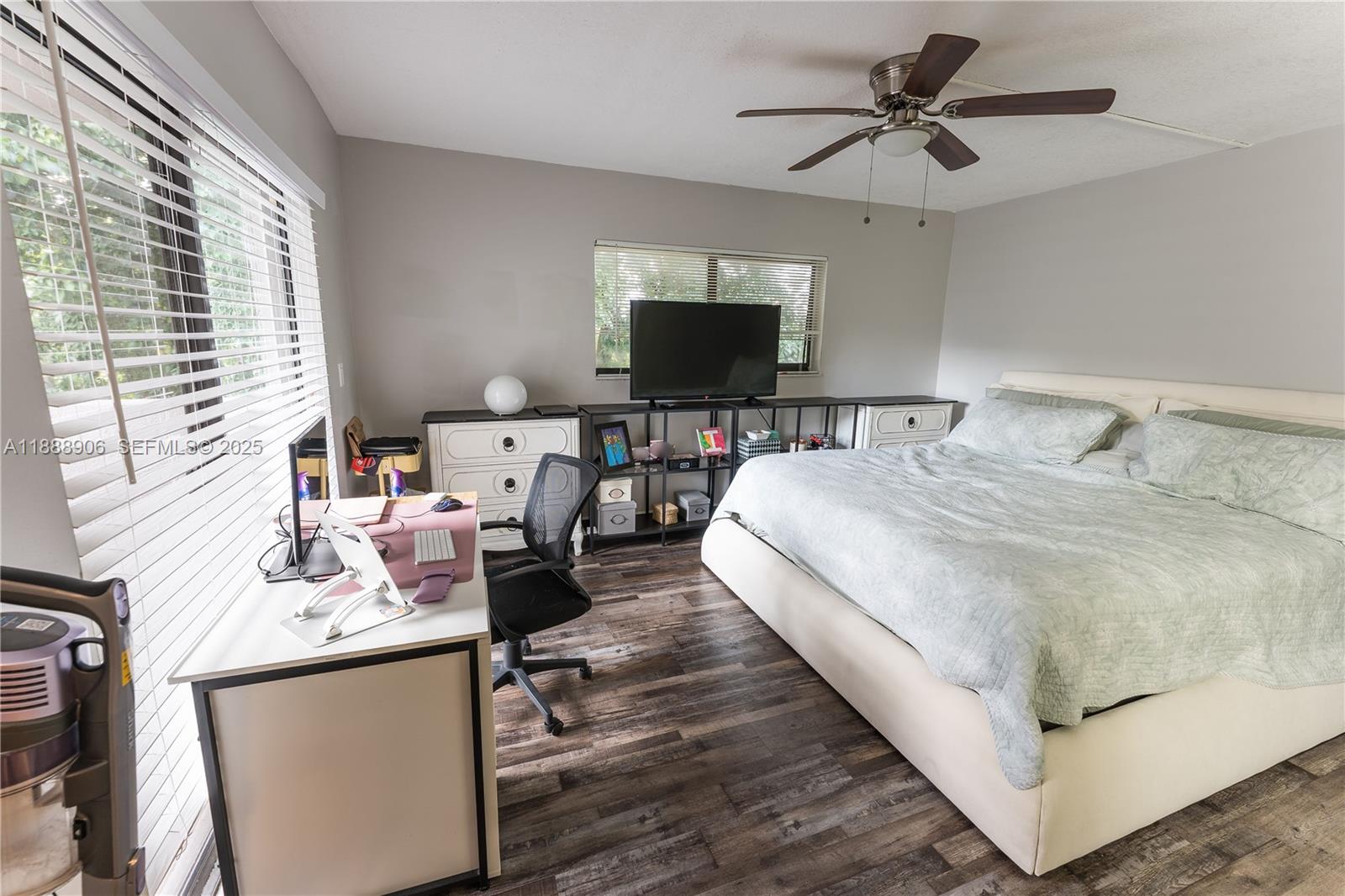 8810 Southwest 132nd Place, Unit 404DN Miami, FL 33186 - Photo 15 of 20 a spacious bedroom with a bed a window and a flat screen television