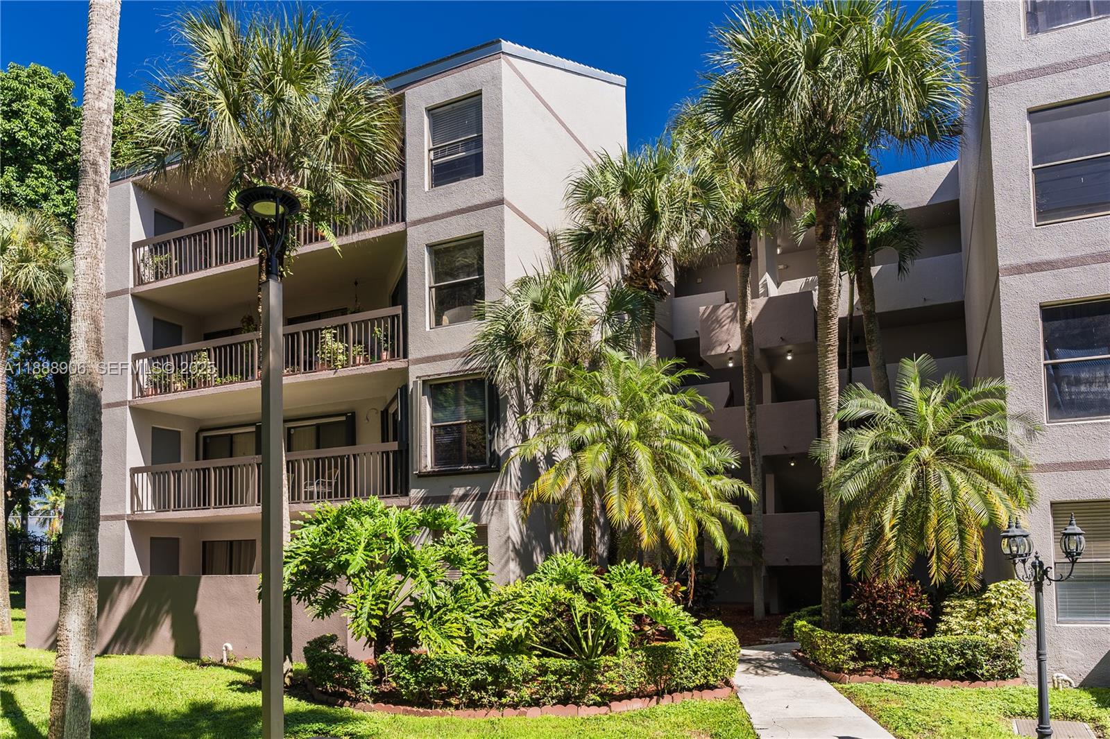 8810 Southwest 132nd Place, Unit 404DN Miami, FL 33186 - Photo 2 of 20 a front view of multi story residential apartment building with yard and retail shops