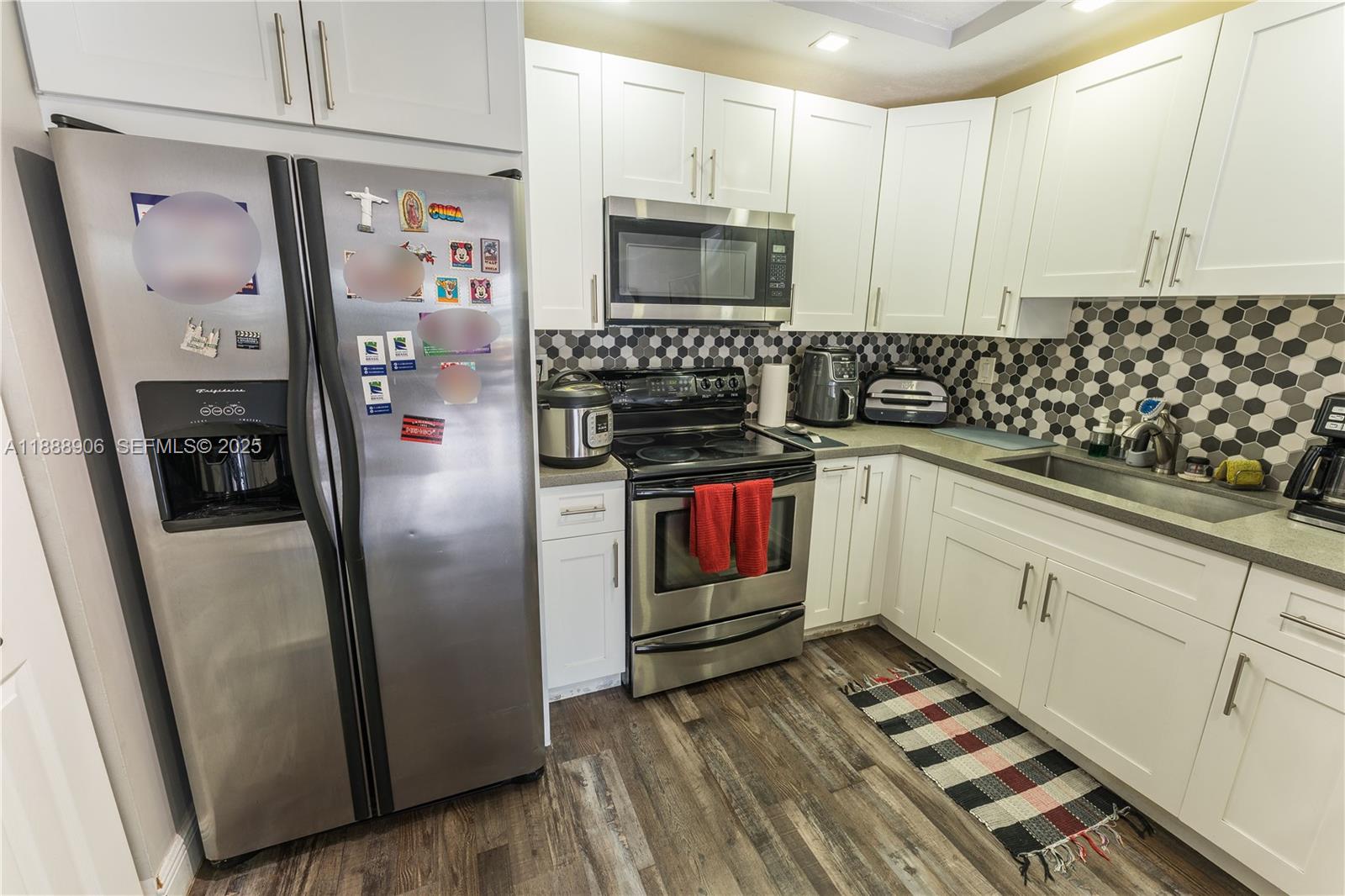 8810 Southwest 132nd Place, Unit 404DN Miami, FL 33186 - Photo 8 of 20 a kitchen with granite countertop a refrigerator and a sink