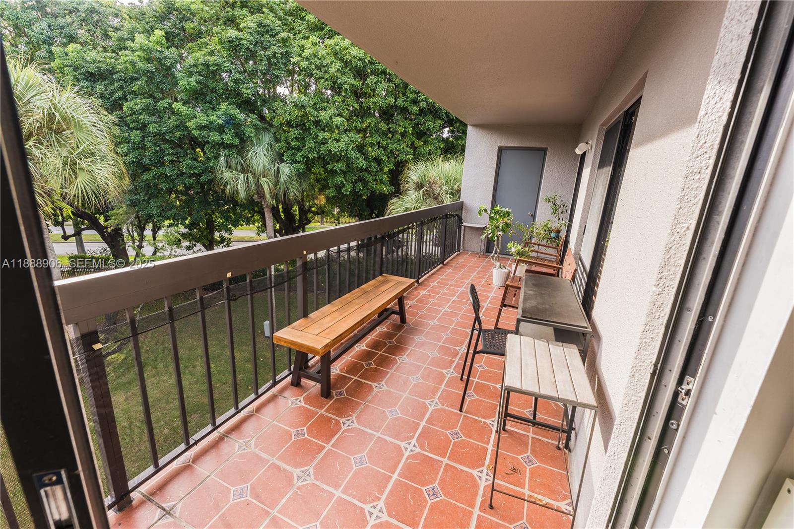 8810 Southwest 132nd Place, Unit 404DN Miami, FL 33186 - Photo 10 of 20 a view of balcony with wooden floor and outdoor seating