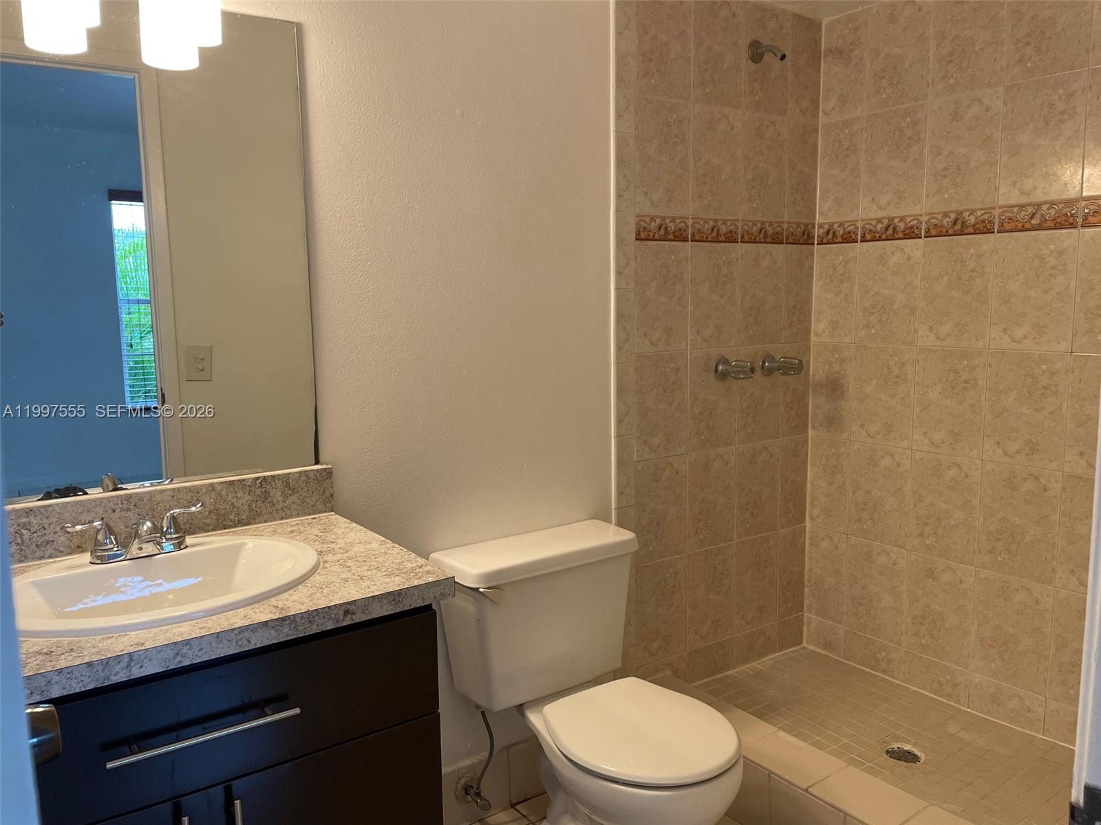 9771 Southwest 211 Street Cutler Bay, FL 33189 - Photo 11 of 19 a bathroom with a sink a toilet and shower
