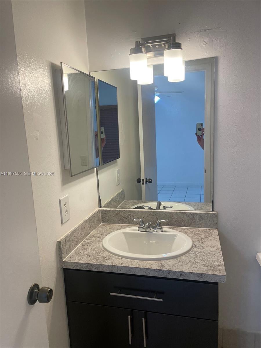 9771 Southwest 211 Street Cutler Bay, FL 33189 - Photo 12 of 19 a bathroom with a granite countertop sink and a mirror