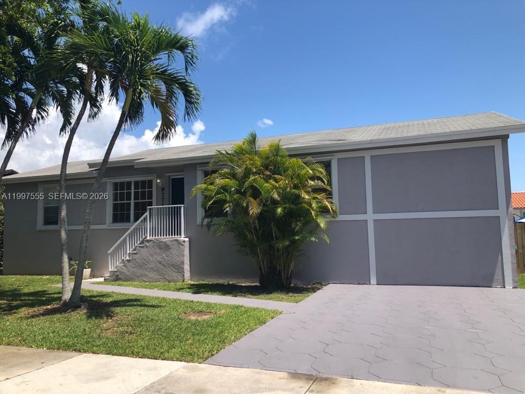 9771 Southwest 211 Street Cutler Bay, FL 33189 - Photo 2 of 19 a front view of a house with a yard and a garage