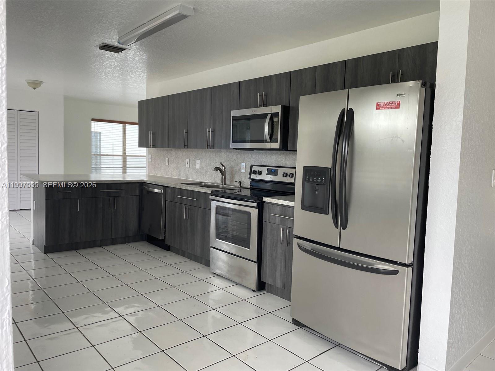 9771 Southwest 211 Street Cutler Bay, FL 33189 - Photo 10 of 19 a kitchen with stainless steel appliances granite countertop a refrigerator and a sink