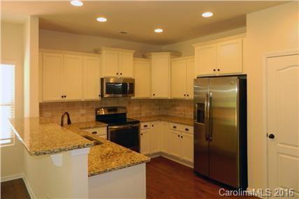 1532 Spring Blossom Trail, Unit SITE 41 Fort Mill, SC 29708 - Photo 14 of 20 a kitchen with granite countertop a refrigerator and a sink