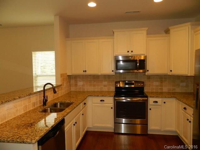 1532 Spring Blossom Trail, Unit SITE 41 Fort Mill, SC 29708 - Photo 6 of 20 a kitchen with granite countertop a sink and stainless steel appliances