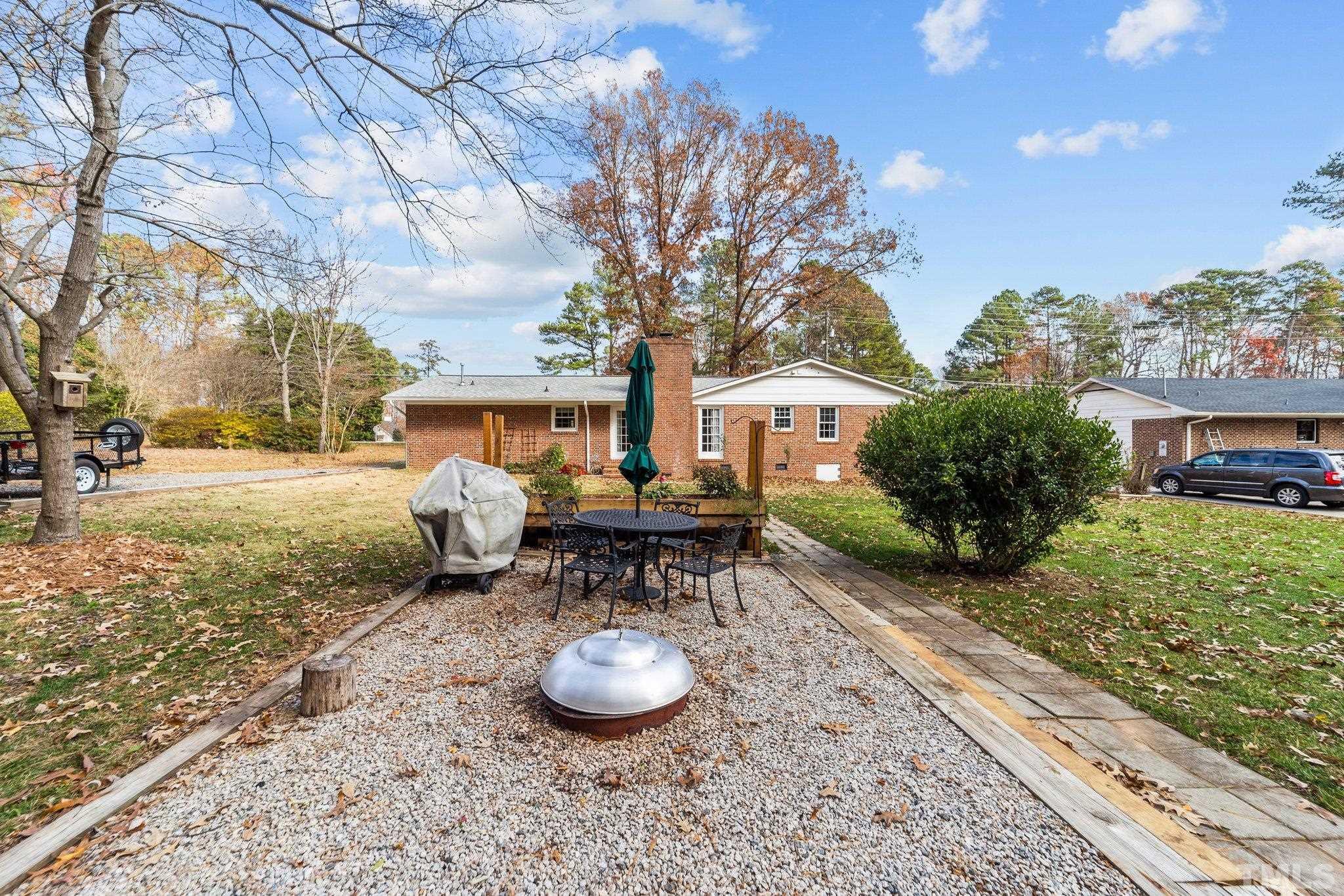 7701 Leesville Road Raleigh, NC 27613 - Photo 13 of 33 a view of a backyard with table and chairs and potted plants