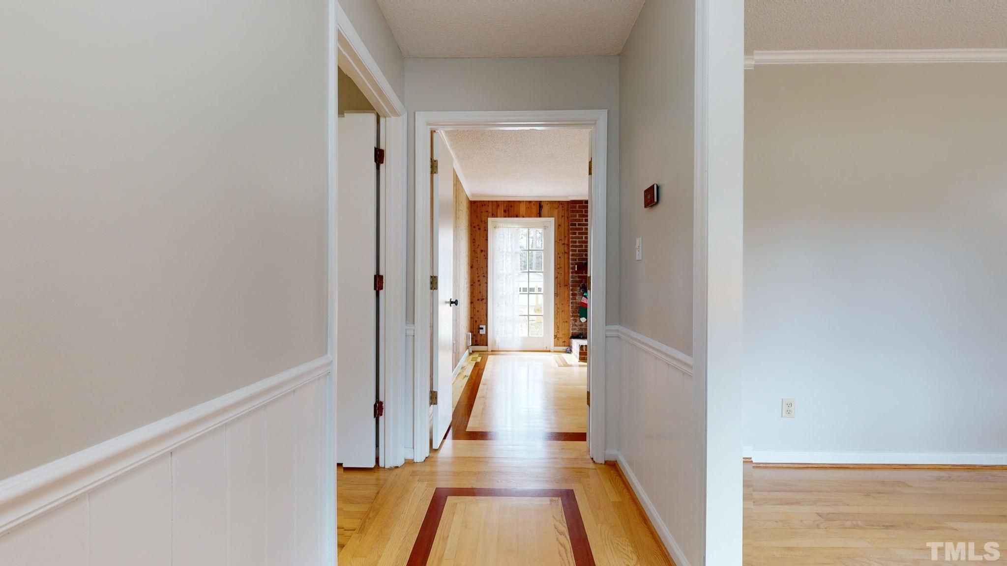 7701 Leesville Road Raleigh, NC 27613 - Photo 14 of 33 a view of a hallway with wooden floor and a bathroom