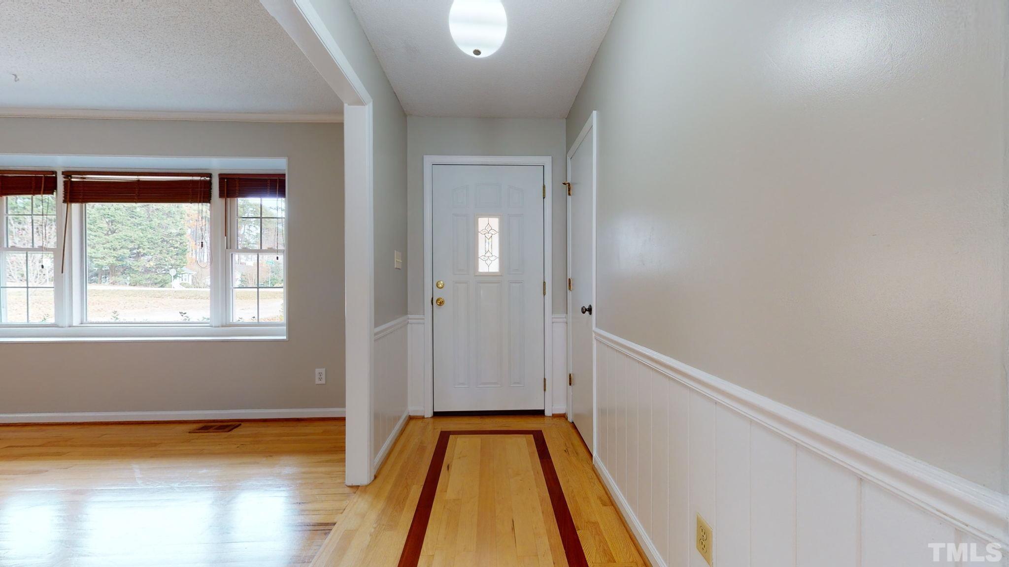 7701 Leesville Road Raleigh, NC 27613 - Photo 15 of 33 a view of a hallway with wooden floor and staircase