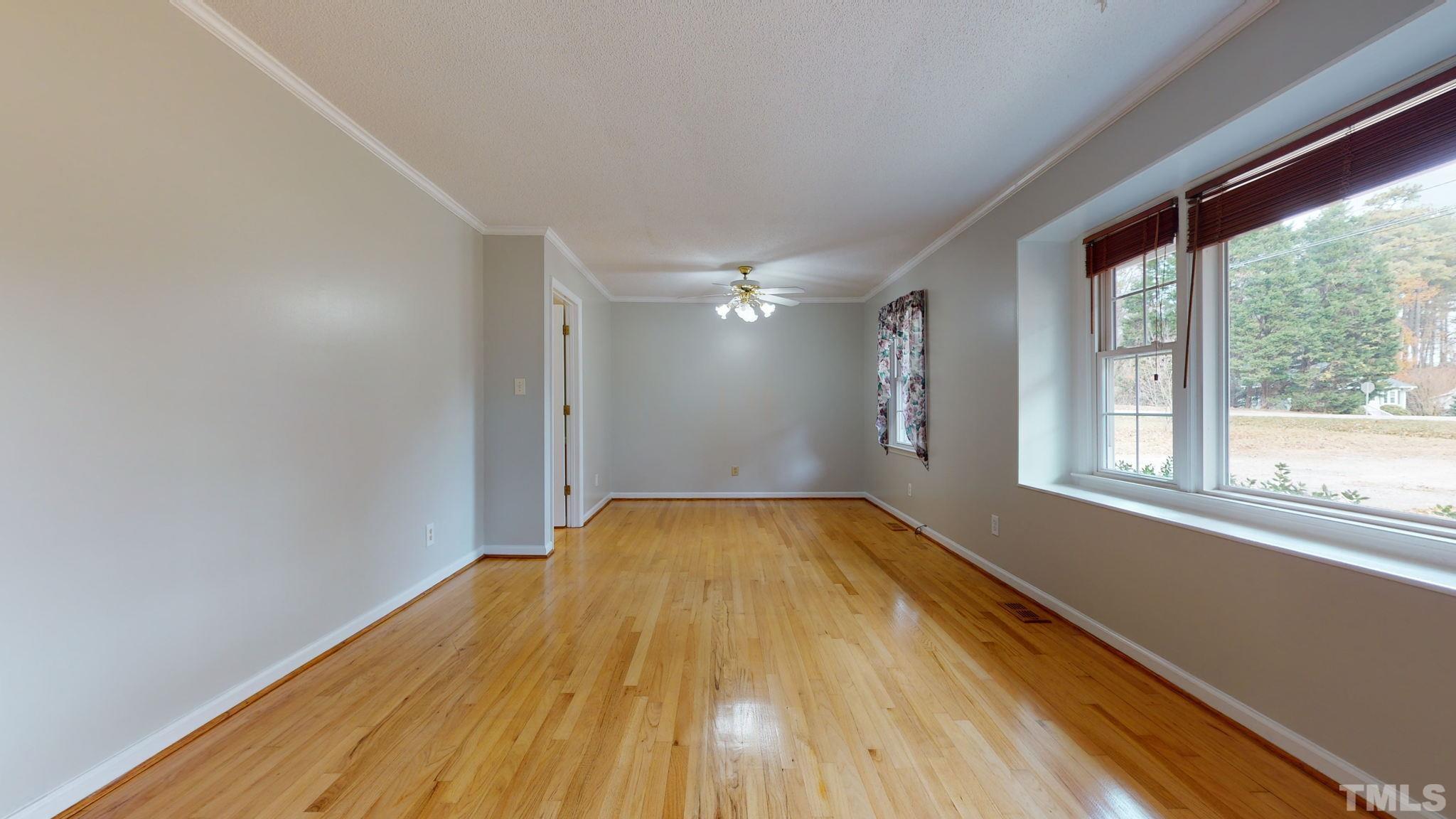 7701 Leesville Road Raleigh, NC 27613 - Photo 16 of 33 a view of empty room with wooden floor and fan