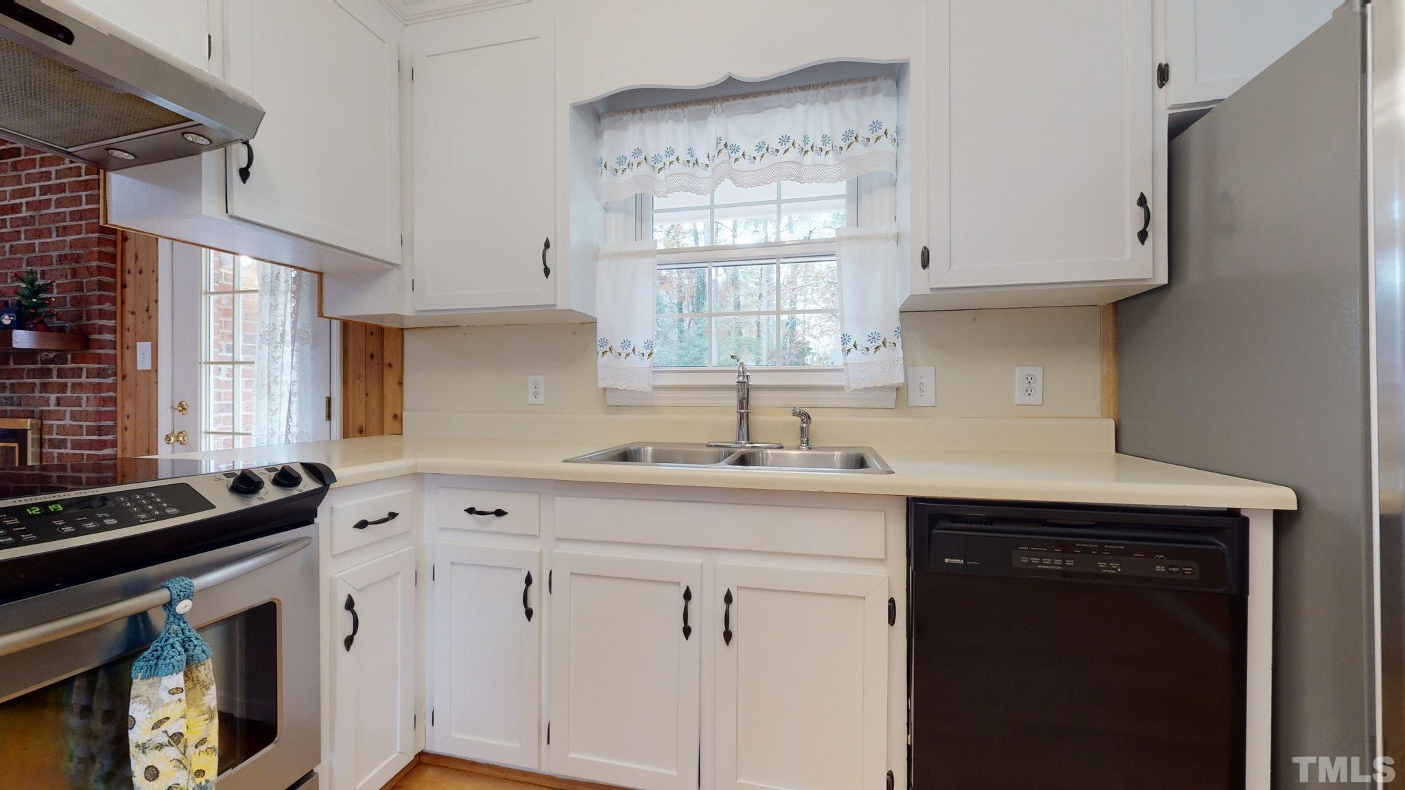 7701 Leesville Road Raleigh, NC 27613 - Photo 21 of 33 a kitchen with granite countertop white cabinets and white appliances