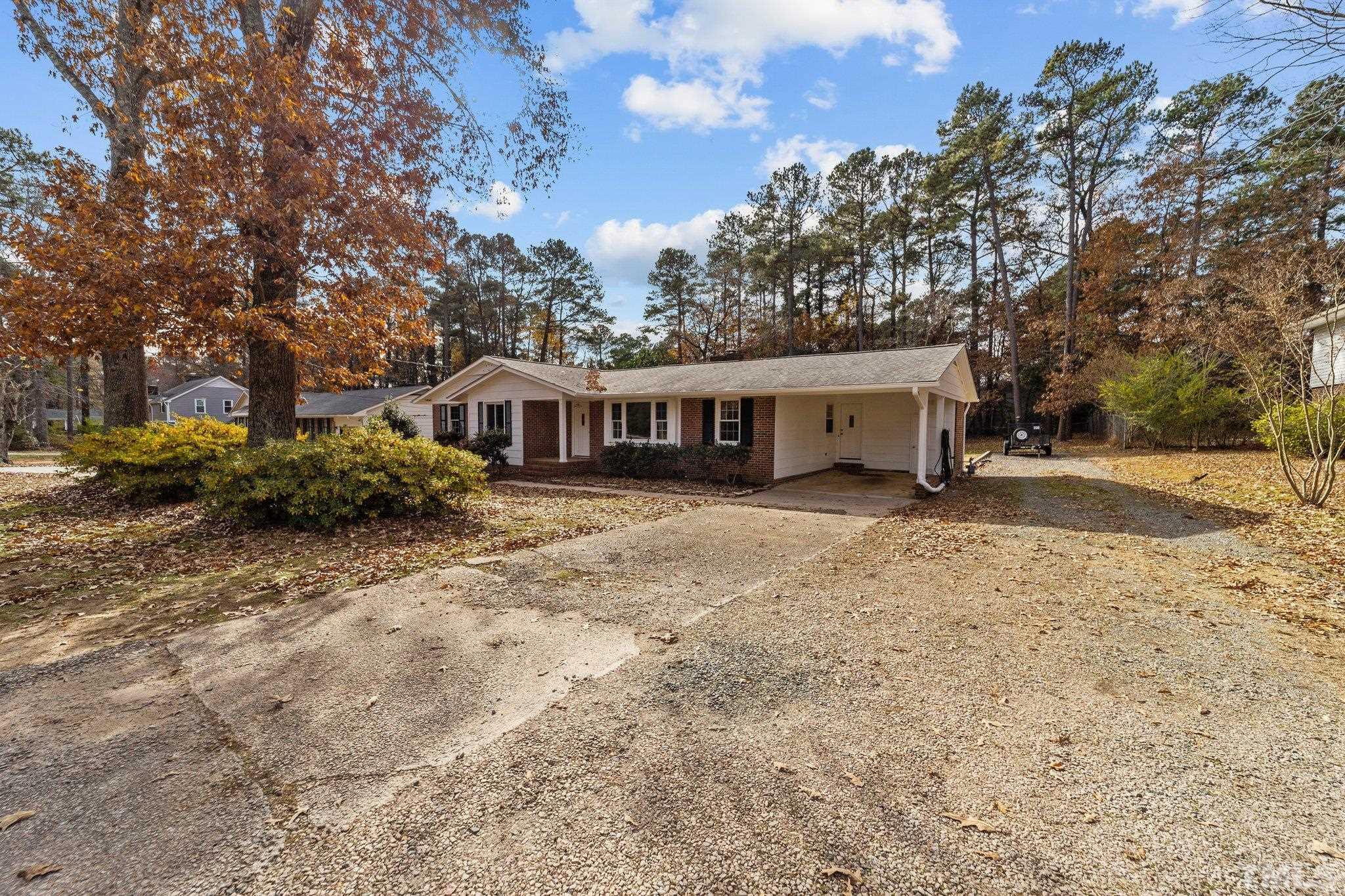 7701 Leesville Road Raleigh, NC 27613 - Photo 4 of 33 a view of a house with a yard and large trees