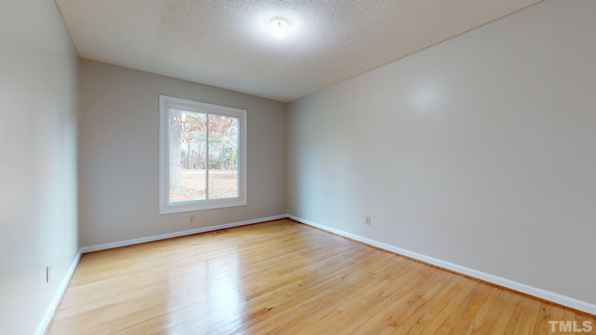 7701 Leesville Road Raleigh, NC 27613 - Photo 31 of 33 an empty room with wooden floor and windows