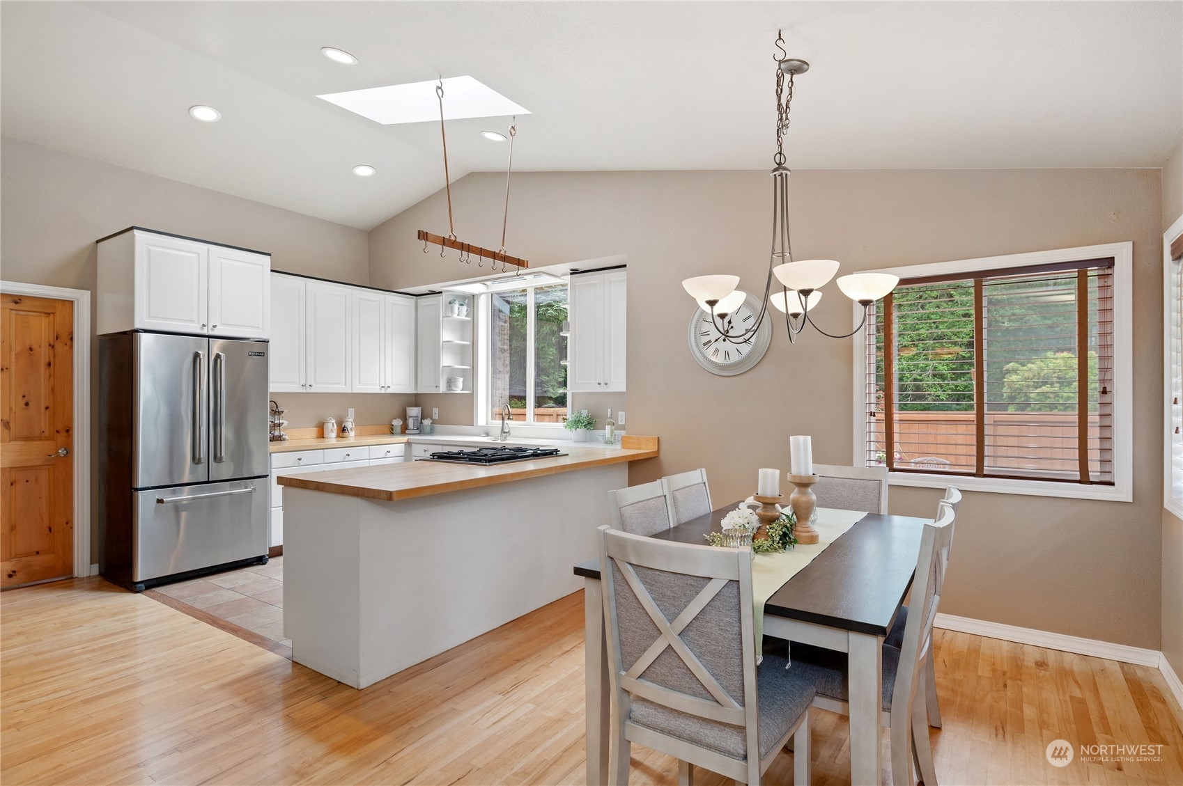 3860 Northeast Iverson Road Poulsbo, WA 98370 - Photo 14 of 40 a kitchen with stainless steel appliances kitchen island a dining table chairs and a chandelier
